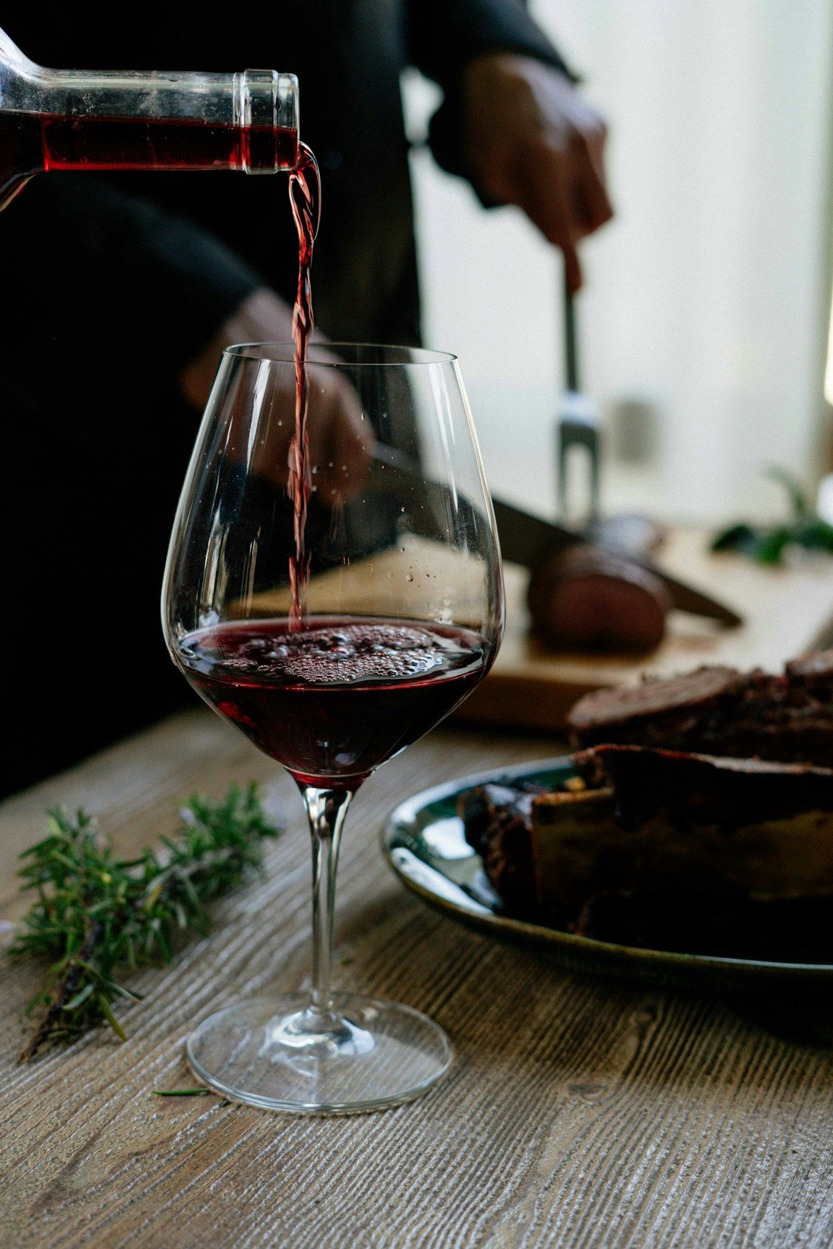 A wine bottle and glasses set for a restaurant table